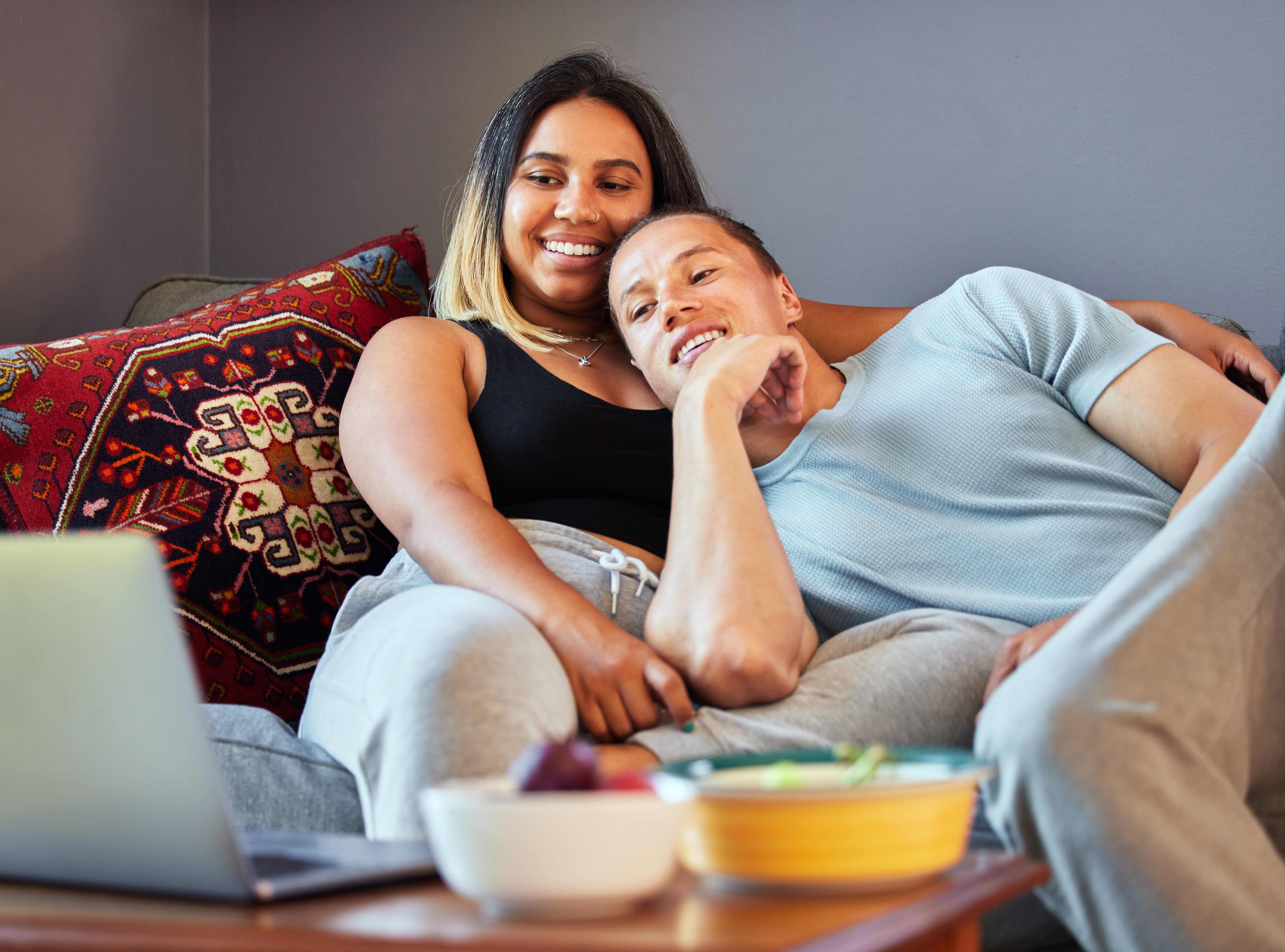 Couple relaxing at home watching laptop